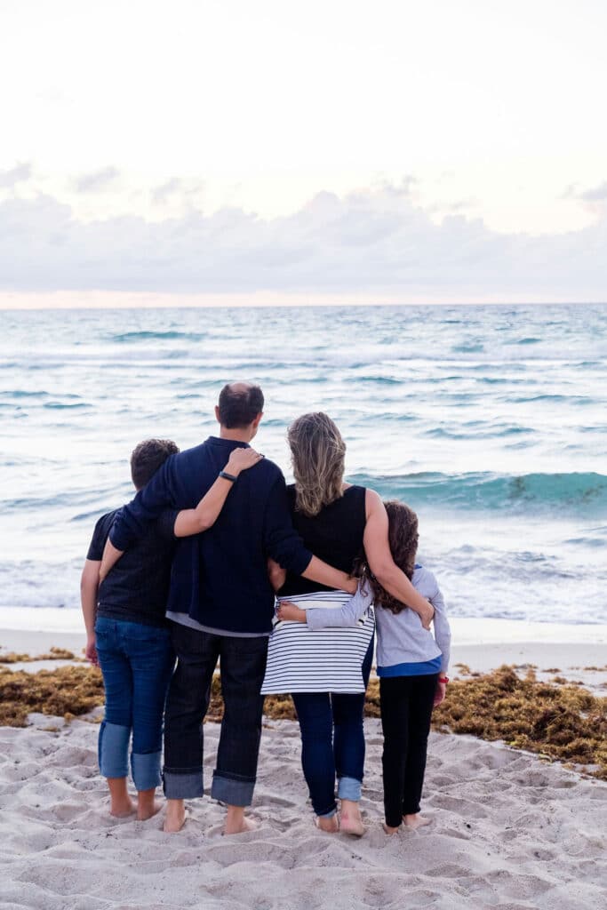 Image of family standing at the beach facing the water showing family therapy and support through teen mental health therapy